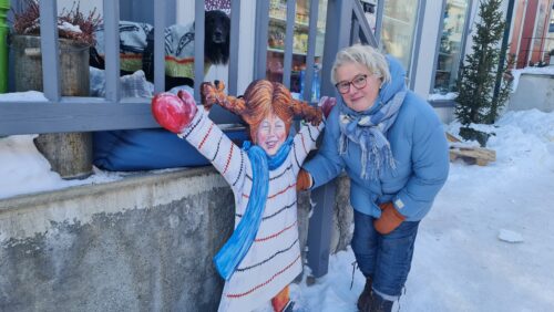 Driver av Lille Røros, Ragnhild Bjerkan har laget Pippi, som står utenfor butikken. Hunden Kompis sto på trappen da bilde ble tatt. Foto: Tove Østby Ragnhild Bjerkan