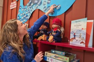 Bibliotekar Mari Snortheim henger opp den siste lappen på sjøormen i Sommerles sommeren 2025. På lørdag leser hun bok i Eventyrlig lørdag. Arkivfoto. Foto: Tove Østby