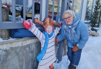 Driver av Lille Røros, Ragnhild Bjerkan  har laget Pippi, som står utenfor butikken. Hunden Kompis sto på trappen da bilde ble tatt. Foto: Tove Østby