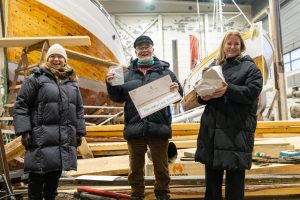 Tilskudd nummer 10 000. Fra venstre styreleder Hanne Kristin Jakhelln, Saltdal Veteranbåtlag ved Per Ragnvald Reffhaug og Kulturminnefondets direktør Pia Wigtil. Foto: Kulturminnefondet