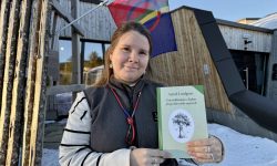 Eva Bendikke Brækkfjell Jåma med en novellesamling av Astrid Lindgren på sørsamisk. Jåma er resepsjonsleder ved det sørsamiske museet Saemien Sijte i Snåsa, som er ett av utsalgsstedene for samiske bøker i Trøndelag.  Foto: Anna Liisa Jåma/Saemien Sijte.