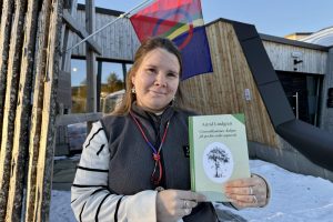 Eva Bendikke Brækkfjell Jåma med en novellesamling av Astrid Lindgren på sørsamisk. Jåma er resepsjonsleder ved det sørsamiske museet Saemien Sijte i Snåsa, som er ett av utsalgsstedene for samiske bøker i Trøndelag.  Foto: Anna Liisa Jåma/Saemien Sijte.