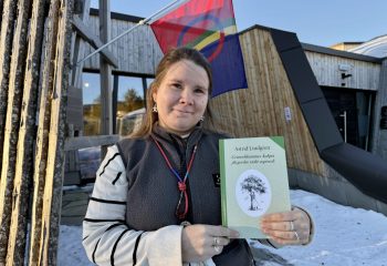 Eva Bendikke Brækkfjell Jåma med en novellesamling av Astrid Lindgren på sørsamisk. Jåma er resepsjonsleder ved det sørsamiske museet Saemien Sijte i Snåsa, som er ett av utsalgsstedene for samiske bøker i Trøndelag.  Foto: Anna Liisa Jåma/Saemien Sijte.