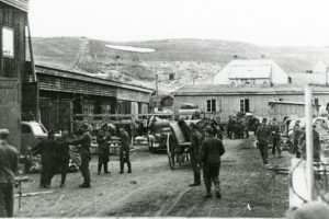 Her tar norske soldater over Stevnehalltomta på Røros med tyskerbrakkene i mai 1945. 
Dette verket har blitt identifisert som fri for kjente opphavsrettsbegrensninger, inklusive alle nærstående rettigheter.