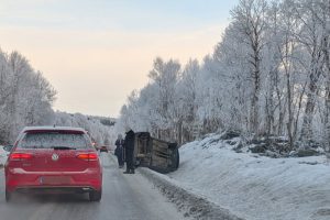 Bilen ligger på siden delvis inne i veibanen.
Foto: Terje Østby